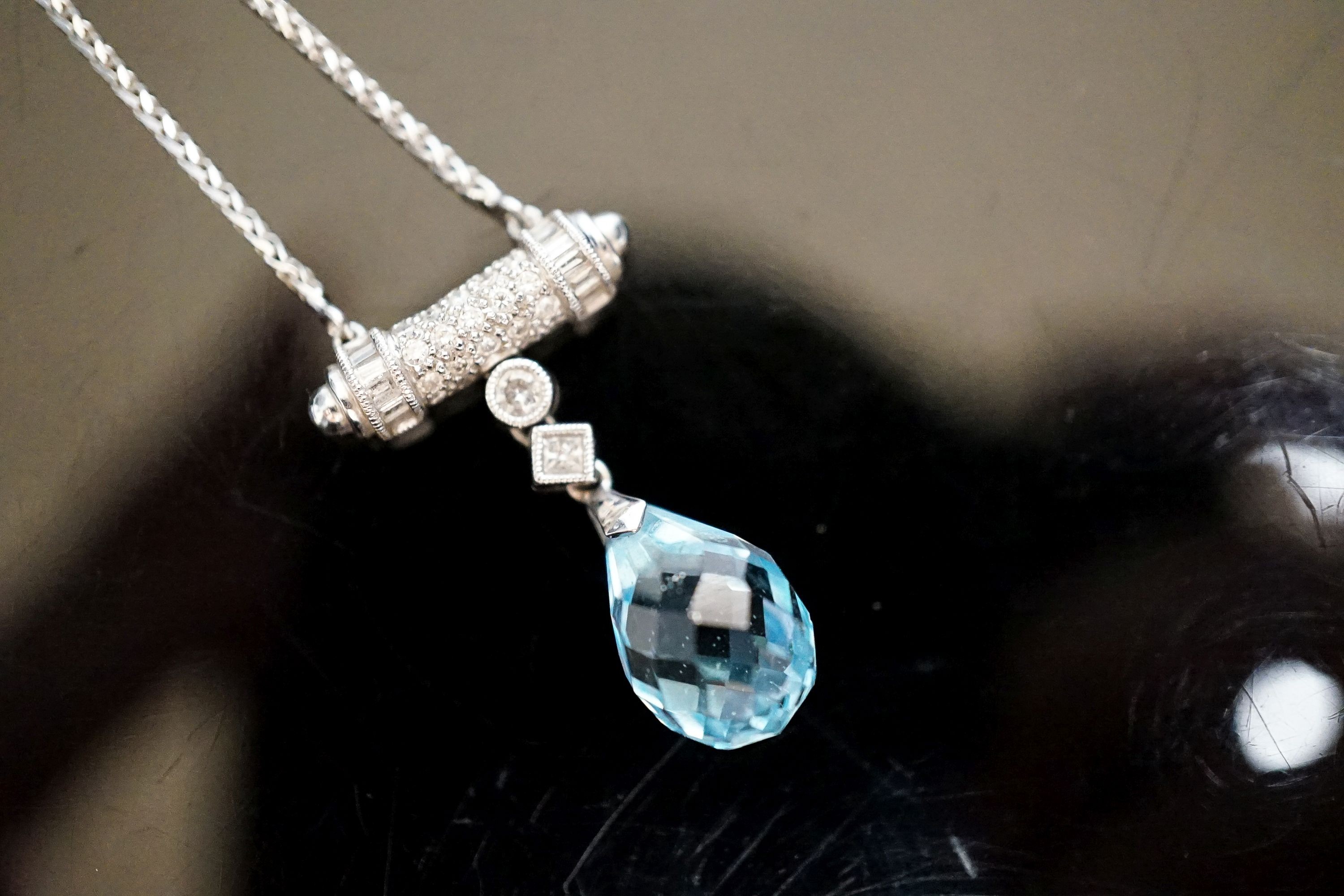 A modern 750 white metal, facet cut pear shaped aquamarine and diamond chip set drop pendant, pendant 25mm, chain 40cm, gross weight 6.2 grams.